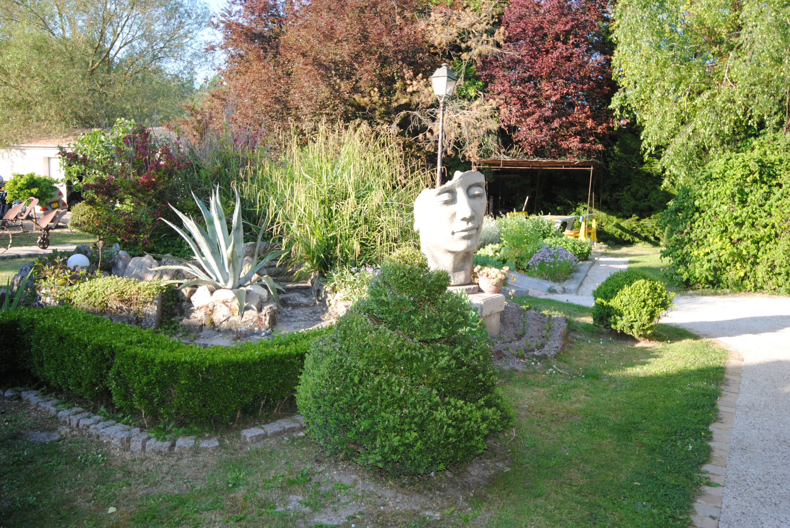 Vue jardin | Le Grand Logis Vue jardin avec sculpture – La Maison d’hôte Le Grand Logis